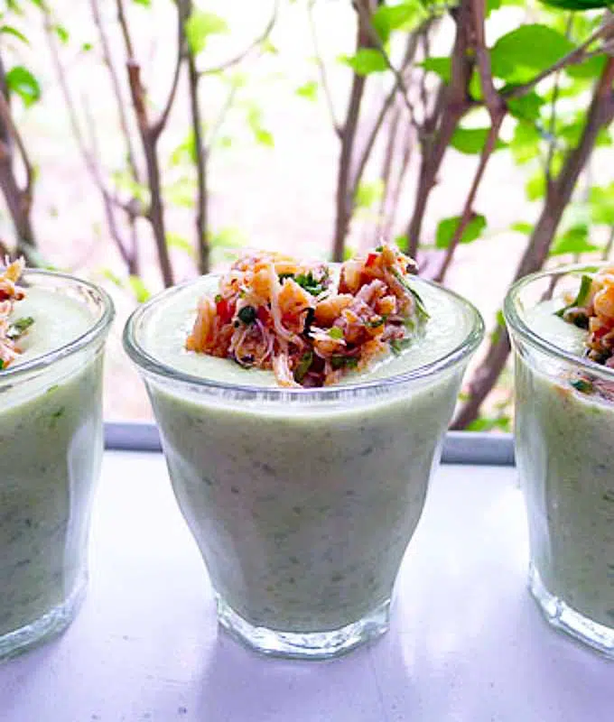 glass with chilled cucumber soup topped with spicy crab