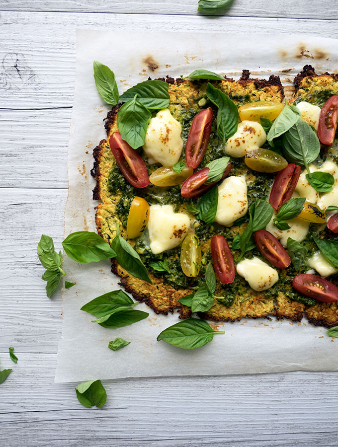 zucchini pizza base recipe with fresh heirloom tomatoes, basil, pesto and mozzarella cheese