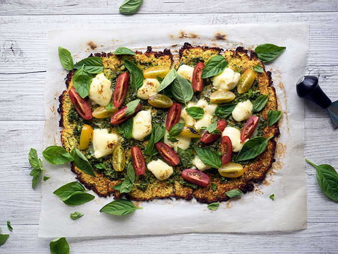 zucchini pizza base recipe with fresh heirloom tomatoes, basil, pesto and mozzarella cheese