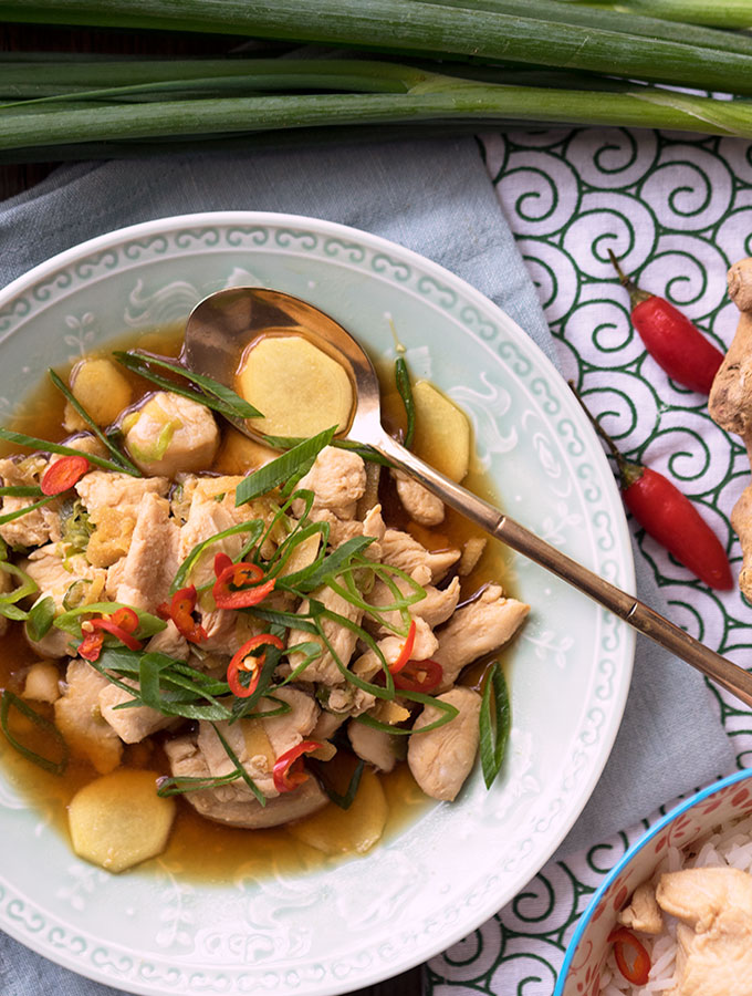 drunken chicken in a large serving bowl with a spoon