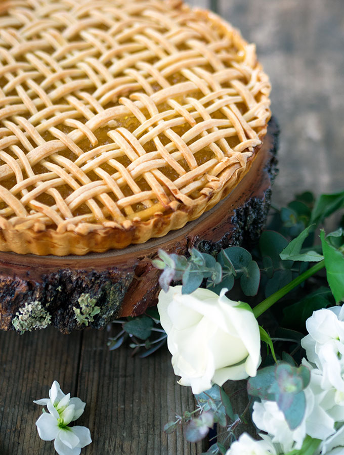 pineapple tart sitting on a round wooden board with white flowers