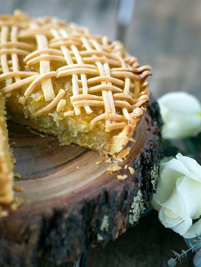 tart sitting on round wooden board with a slice removed