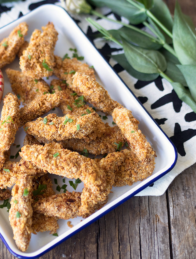 Crunchy Honey & Almond Baked Chicken Fingers, with a Secret Ingredient. Oven baked and not fried, golden and super crunchy. Served with a hot sauce mayo.