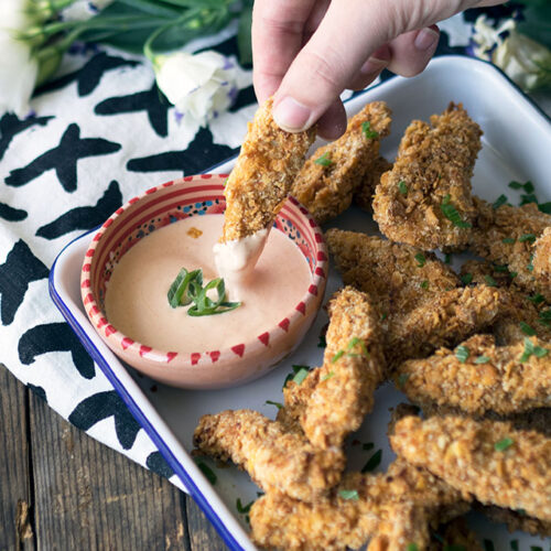Crunchy Honey & Almond Baked Chicken Fingers, with a Secret Ingredient. Oven baked and not fried, golden and super crunchy. Served with a hot sauce mayo.