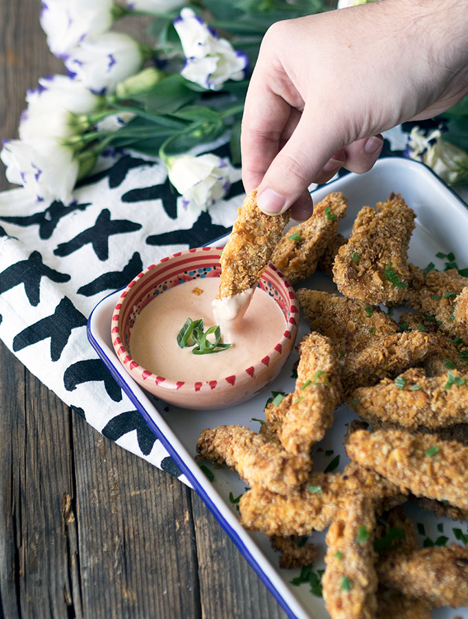 Crunchy Honey & Almond Baked Chicken Fingers, with a Secret Ingredient. Oven baked and not fried, golden and super crunchy. Served with a hot sauce mayo.