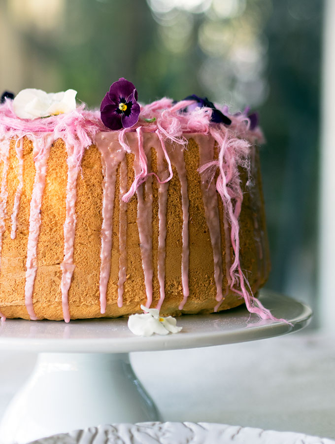 Light as air Blood Orange Chiffon Cake decorated with blood orange icing, Persian fairy floss and pretty edible flowers.