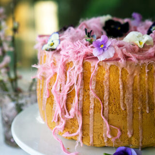 Light as air Blood Orange Chiffon Cake decorated with blood orange icing, Persian fairy floss and pretty edible flowers.