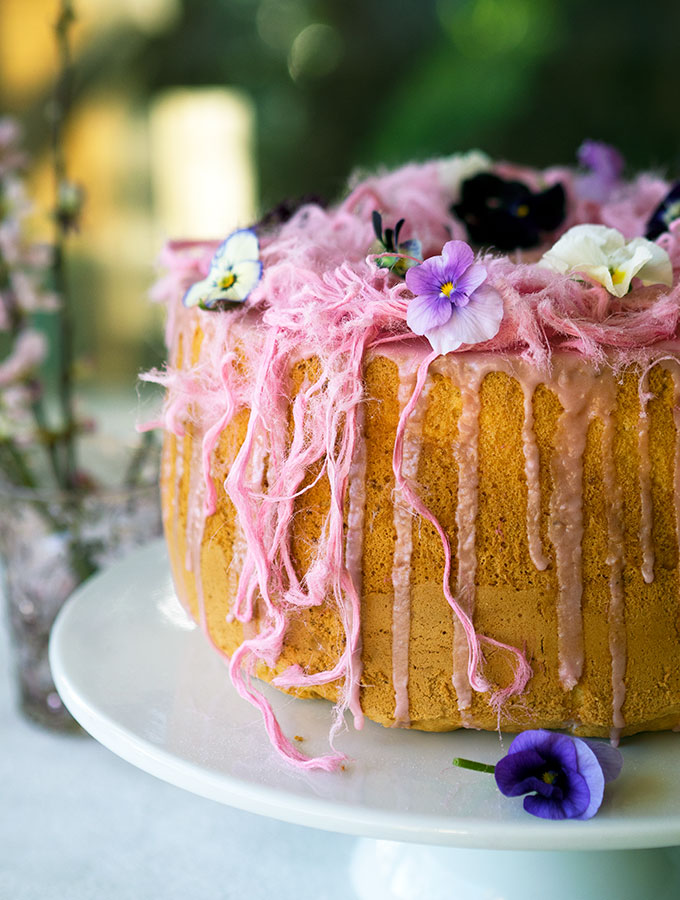 Light as air Blood Orange Chiffon Cake decorated with blood orange icing, Persian fairy floss and pretty edible flowers.