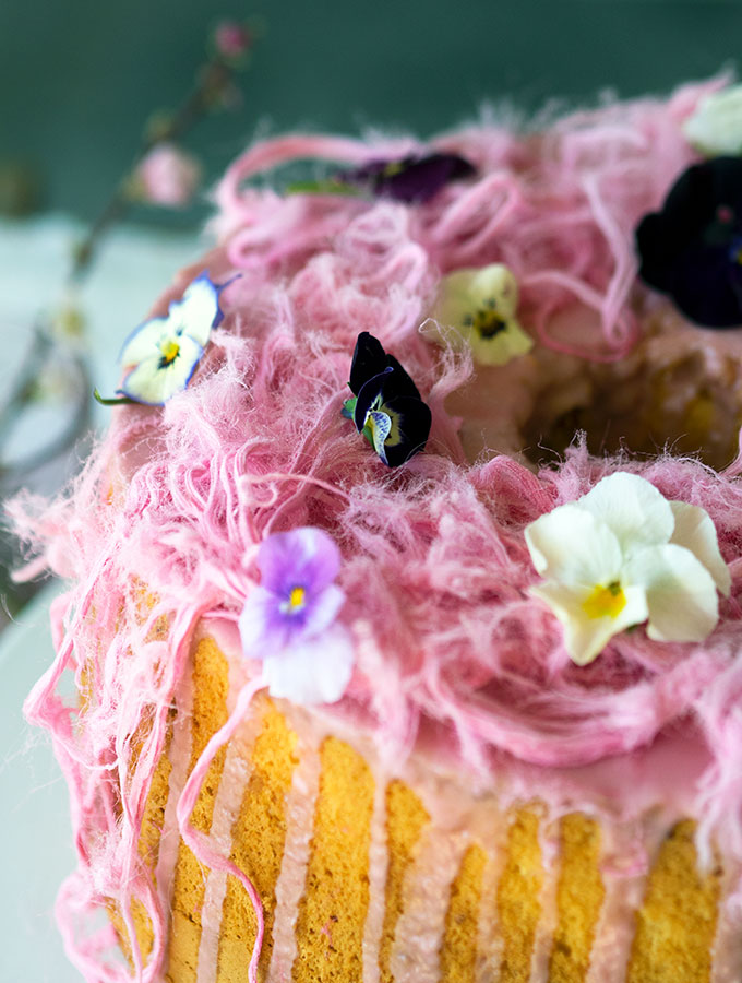 Light as air Blood Orange Chiffon Cake decorated with blood orange icing, Persian fairy floss and pretty edible flowers.