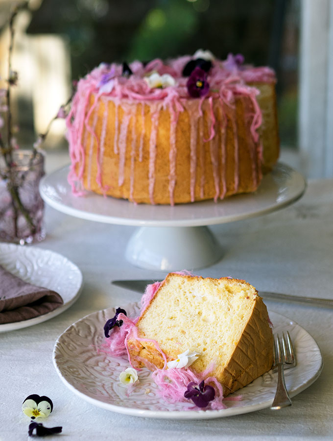 Light as air Blood Orange Chiffon Cake decorated with blood orange icing, Persian fairy floss and pretty edible flowers.