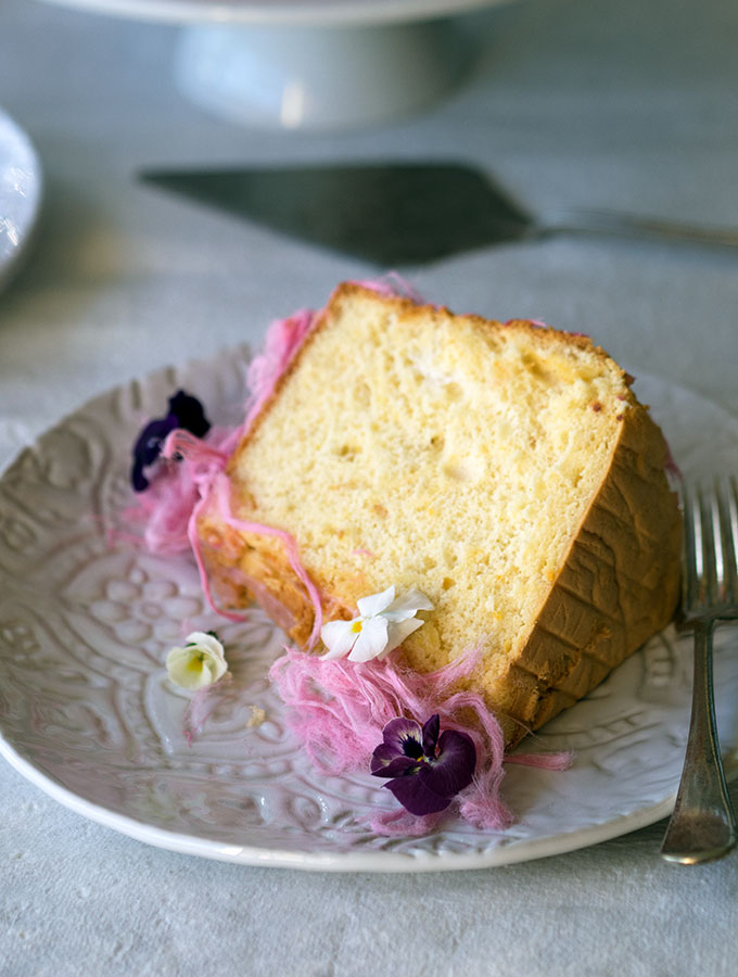 Light as air Blood Orange Chiffon Cake decorated with blood orange icing, Persian fairy floss and pretty edible flowers.