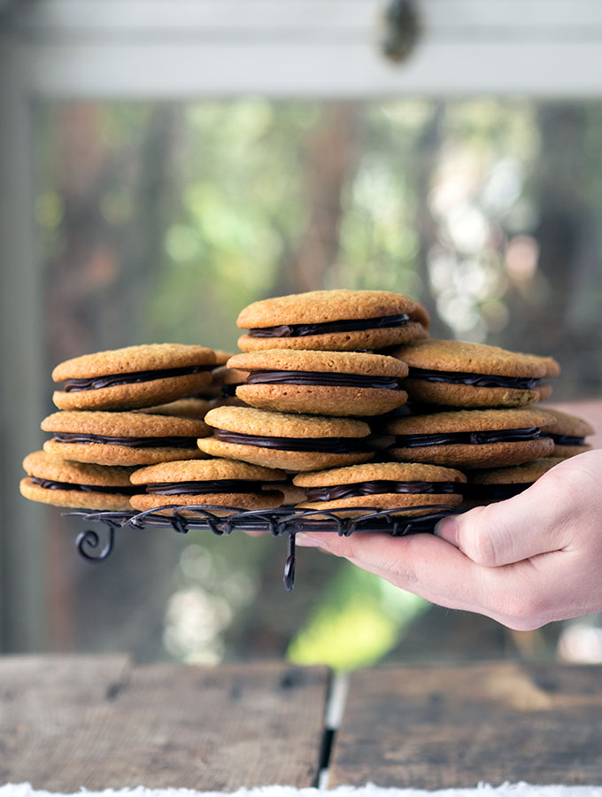 Coconut chocolate ganache cookie sandwiches are made from delicious buttery chewy coconut cookies, which are filled with decadent dark chocolate ganache