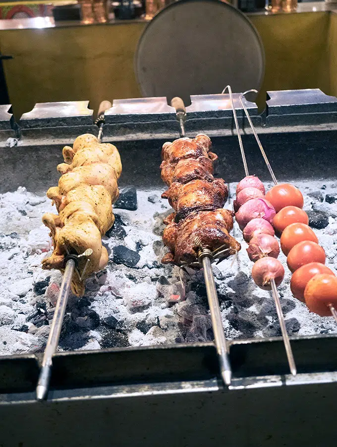 Chickens, onions and tomatoes being roasted at Al Hadheerah Desert Restaurant Dubai