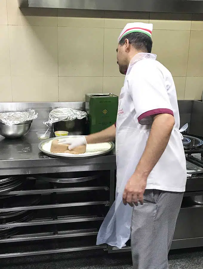 Chef sponging down base of Kanafeh