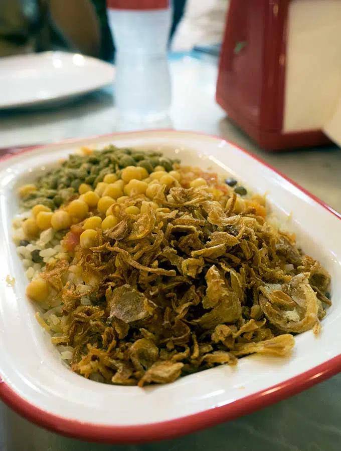 Kushari with fried onions, corn and peas in Dubai