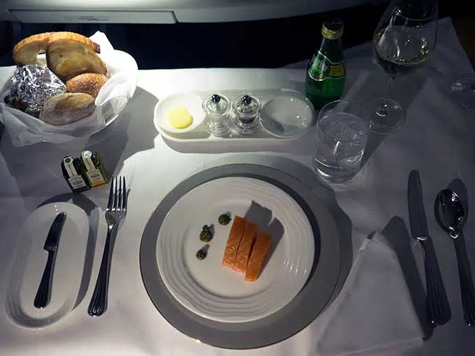 Emirates First Class Sydney to Bangkok salmon entree on plate with dots of sauce