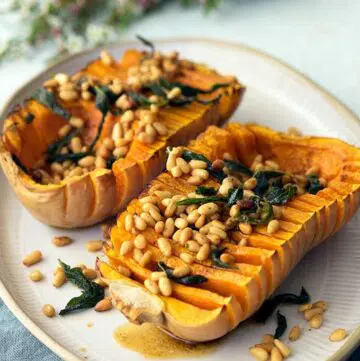 Hasselback pumpkin with browned butter pine nuts and sage on a serving plate