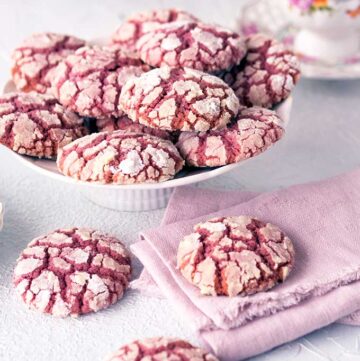 Ruby Chocolate Crackle Cookies with extra on the table with a brush pink linen napkin