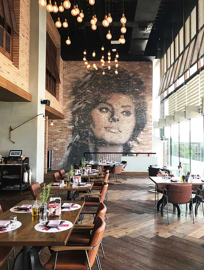 tables at Basta restaurant with a mural of sophia loren on the back wall