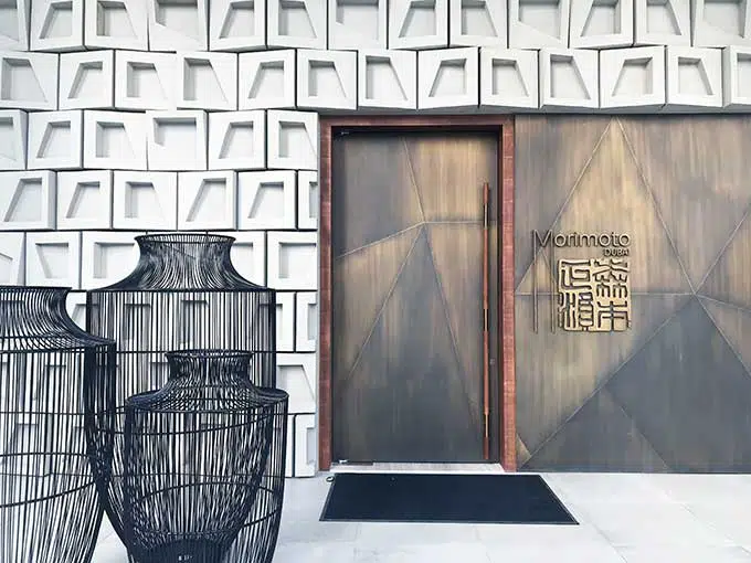 outside of Morimoto Dubai, metal doors, wicker vases and white tiles