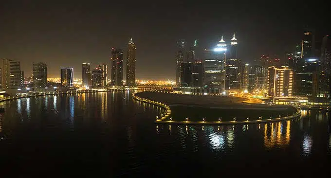 view of dubai water canal at night with buildings lit up