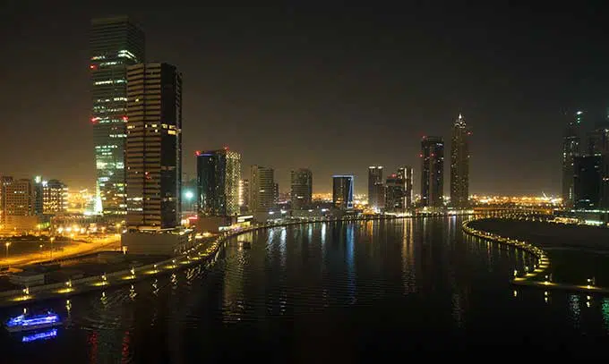 view of dubai water canal at night with buildings lit up