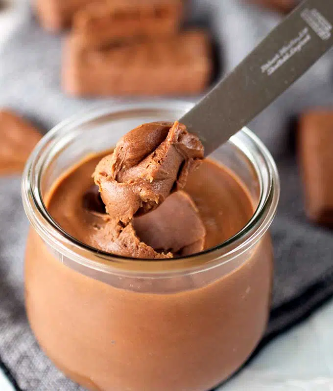 Tim Tam spread in a jar with a knife scooping some out