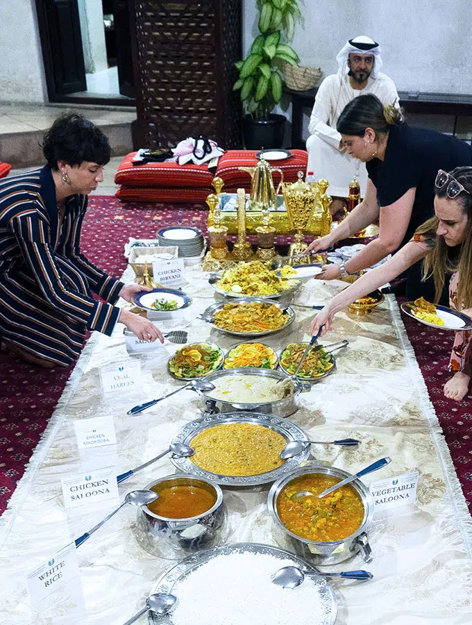 people helping themselves to various arabic dishes for iftar during ramadan