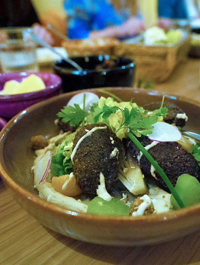 falafel and salad in a pottery bowl on a dining table