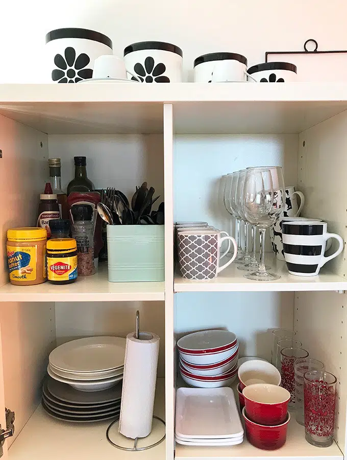 open cupboard in kitchen with cups, glasses, plates, bowls and condiments, at the dog house port macquarie