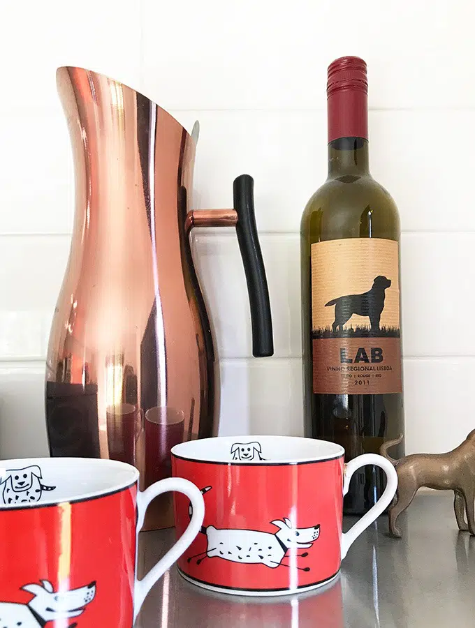 copper water jug, bottle of red wine with dog log, two red coffee cups with dogs on them at the dog house port macquarie