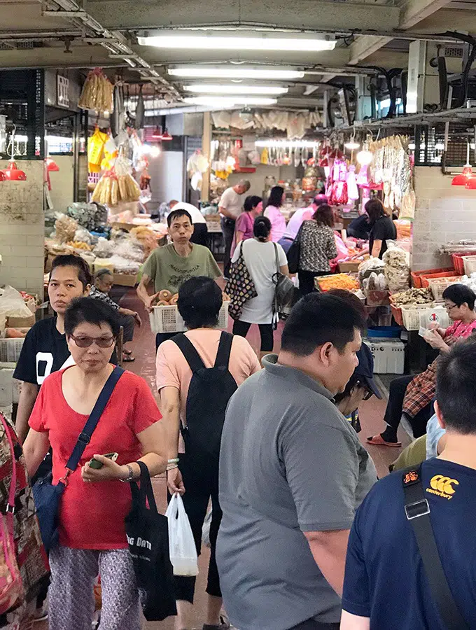 people walking around the vegetable hall of the red market macao