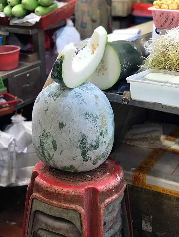 slice of winter melon sitting on top of a whole winter melon at the red market macao