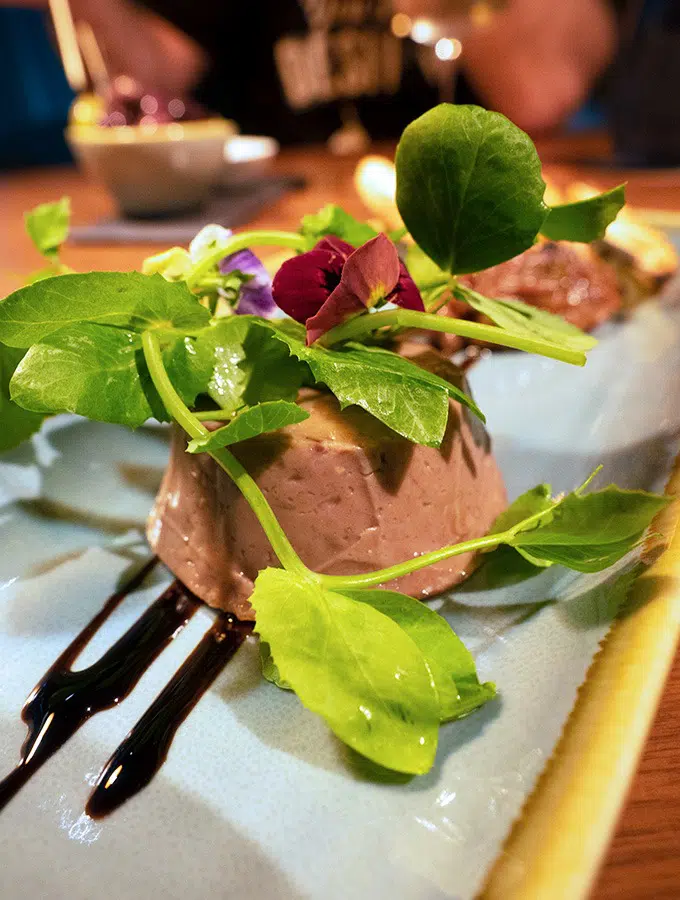 kangaroo rillette on a long white place with green leaves sitting on top of it