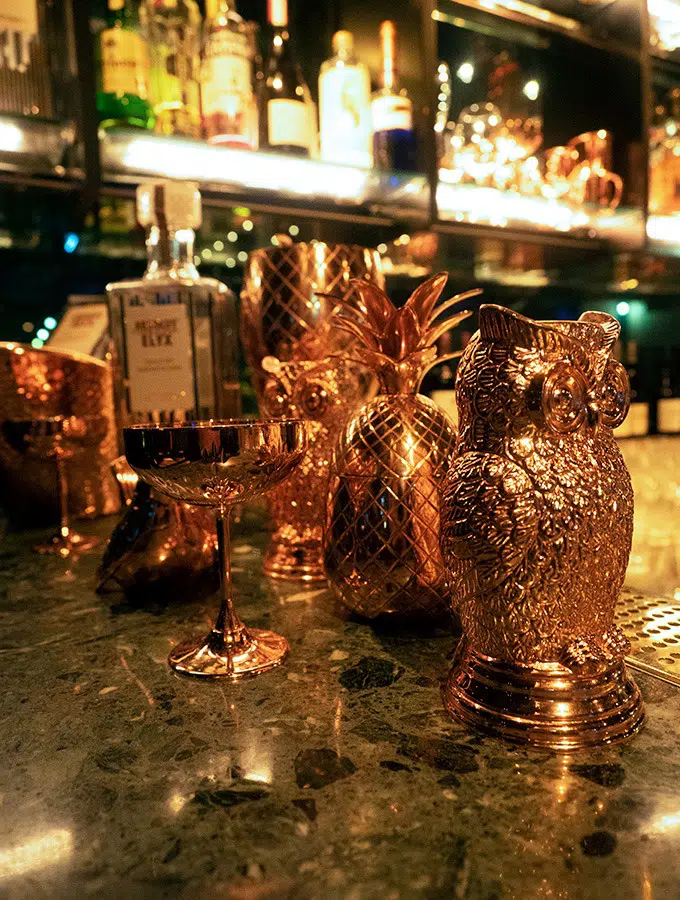 various copper mixology items on a bar