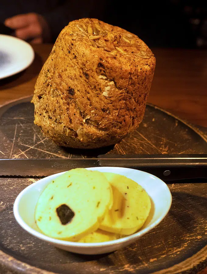 bread on a bread board with butter at the front