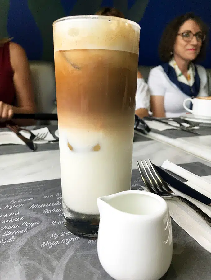 iced coffee in a glass showing the three layers of the drink