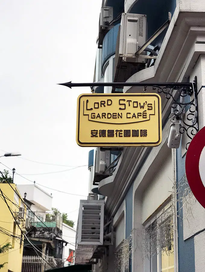 Lord Stows cafe sign hanging from an iron bar attached to the side of a building