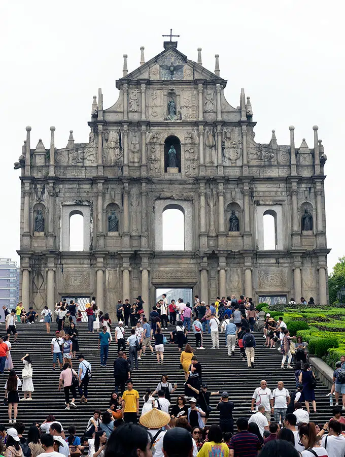 front view of the ruins of St Paul in Macao with people on the steps in front