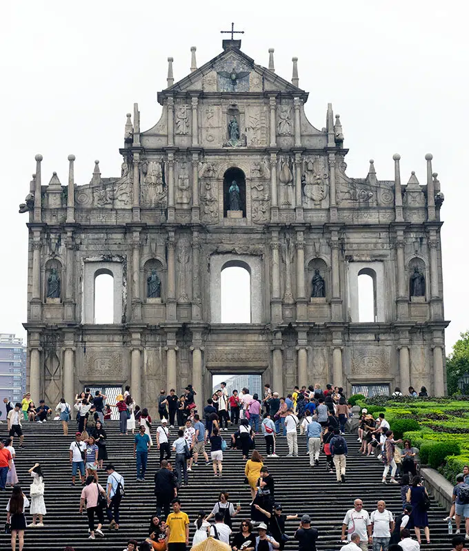 front view of the ruins of St Paul in Macao with people on the steps in front