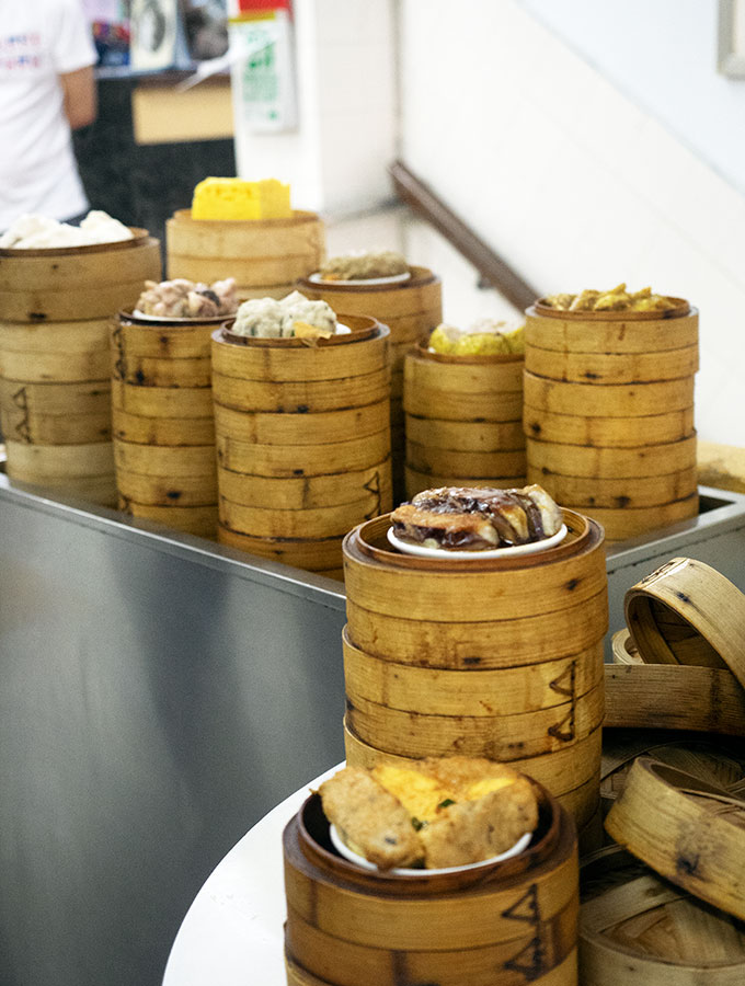 selection of dumplings stacked in steamer baskets on a metal trolley and table