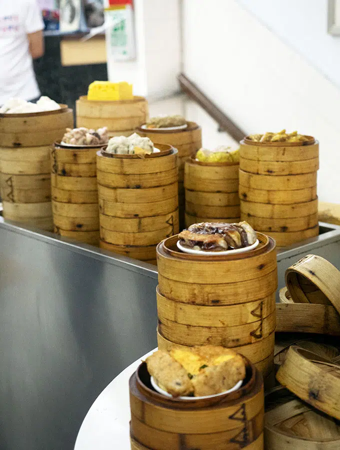 selection of dumplings stacked in steamer baskets on a metal trolley and table