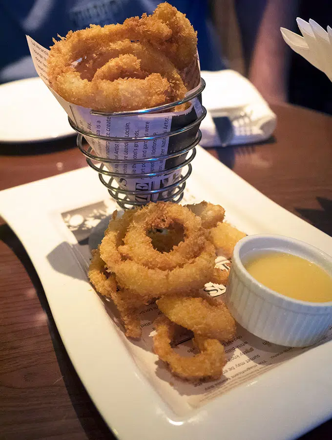 onion rings on a plate with dipping sauce