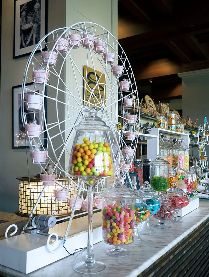 candy bar with various candies in glass jars and a ferris wheel