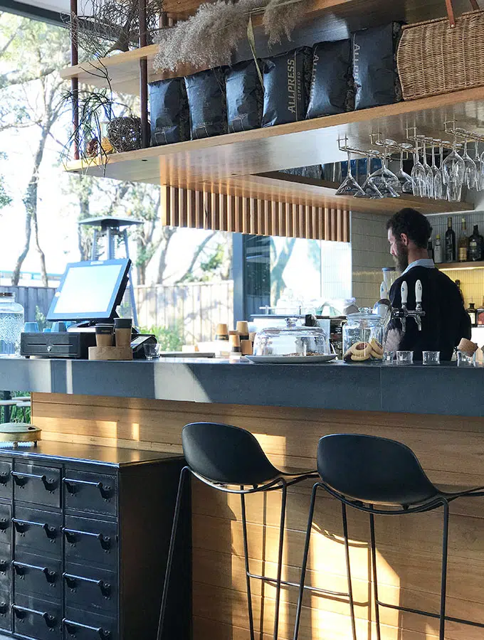 barista standing behind the bar making coffee