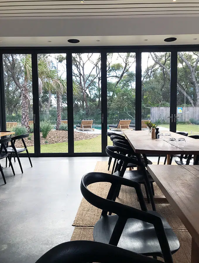 restaurant tables and chairs with large glass windows in the back ground