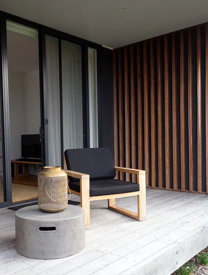 chair with black cushions and table on the deck of the villa