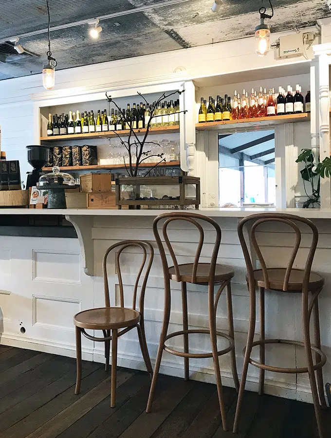 the bar at queen street eatery in berry with chairs, coffee machine and wine bottles behind
