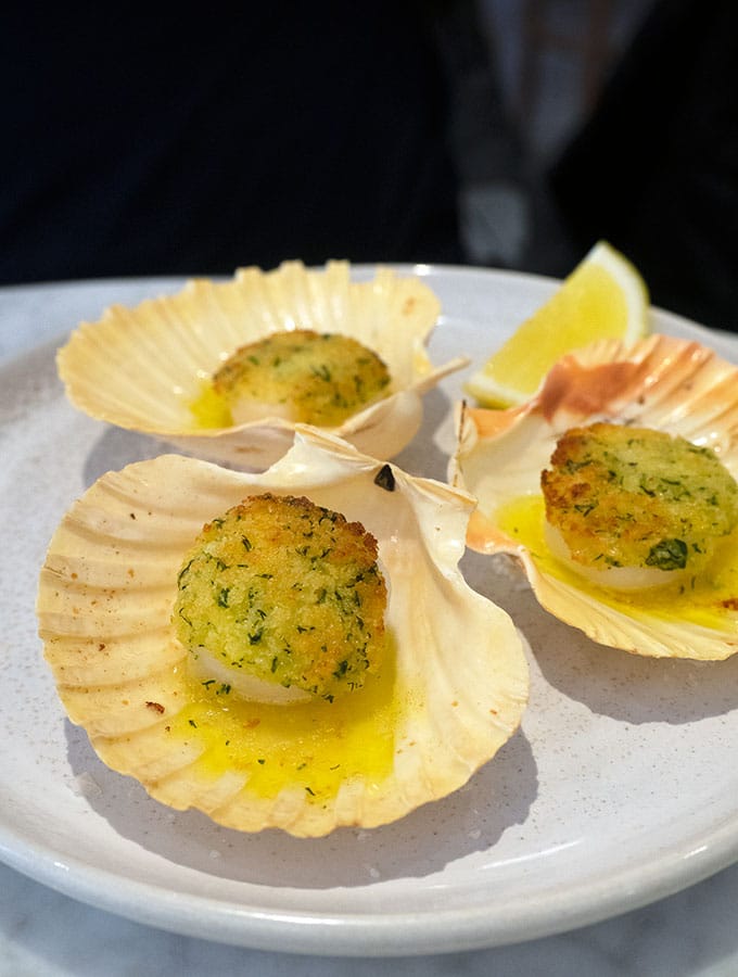 baked sea scallops on the shell served on a plate