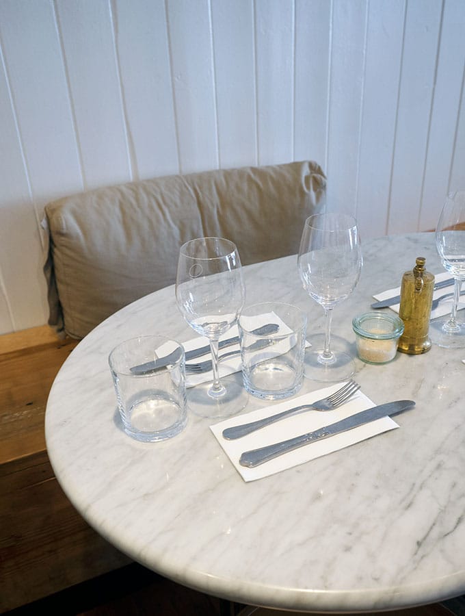 a marble table at queen street eatery set with glasses knives and forks